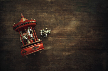 Antique toy carousel with horses. A vintage wooden toy is lying on the table. A clockwork musical...