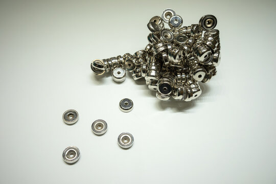 There are a lot of neodymium magnets on a white background. Magnets for fixing metal products.