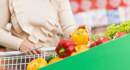 Woman buying fresh vegetables at the supermarket
