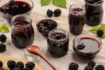 Tasty blackberry jam and fresh berries on white wooden table