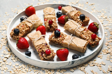 Tasty granola bars and ingredients on light table