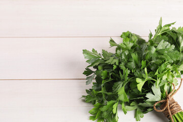 Bunch of fresh parsley on white wooden table, top view. Space for text
