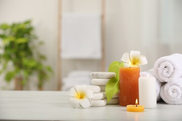 Composition with different spa products and plumeria flowers on white marble table indoors, space for text