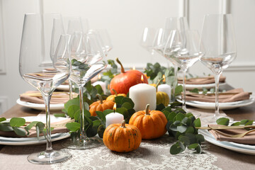 Beautiful autumn table setting. Plates, cutlery, glasses, pumpkins and floral decor