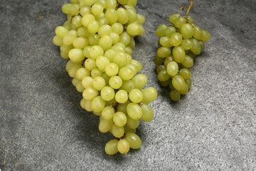 Delicious fresh green grapes on grey textured table