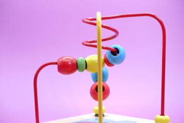 Children's educational toy isolated on purple background. toddler toys. toys with iron wire and beads.
