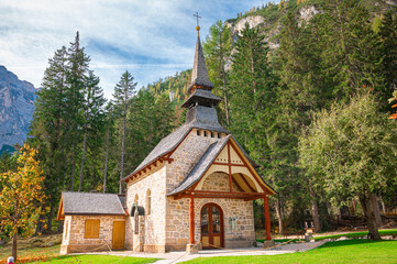 Fototapeta na wymiar Picturesque little church on the shore of Braies Lake in Italy's Dolomites