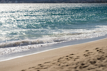 Waves rolling on a sandy beach on a sunny day