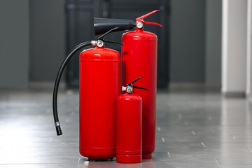 Three new red fire extinguishers in hall