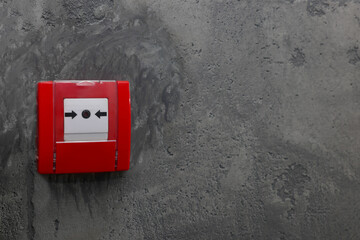 Fire alarm push button on grey wall, space for text