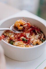 Appetizing Thai food of pumpkin porridge with shrimps served with greens and seeds in restaurant