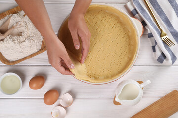 Woman making quiche at white wooden table, top view