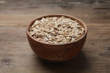 Bowl of oatmeal on wooden table, closeup