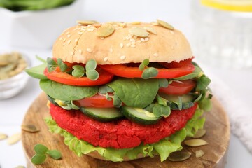 Tasty vegan burger with vegetables, patty and microgreens on white table, closeup