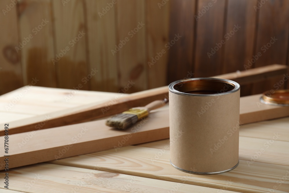 Sticker Can with wood stain on wooden surface. Space for text