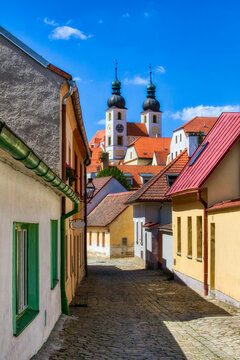 Narrow, Cobbled Street in Telc in the Czech Republic, with the Towers of the Name of Jesus Church