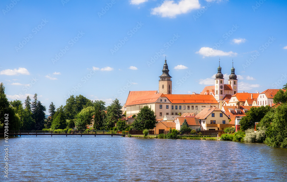 Poster view towards the castle of telc in the czech republic, with the name of jesus church and the tower o