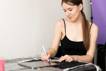 a caucasian woman making tattoo sketch on paper in the office