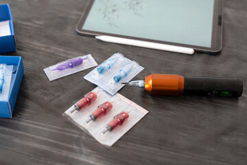 a layout on the desktop with tattoo tools: machine and needle