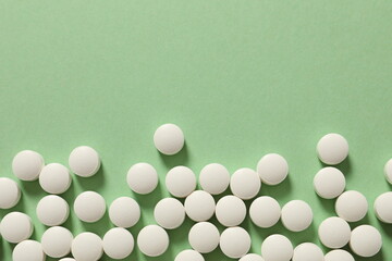 white pills on green background
