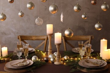 Christmas table setting with burning candles and festive decor