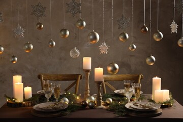Christmas table setting with burning candles and festive decor