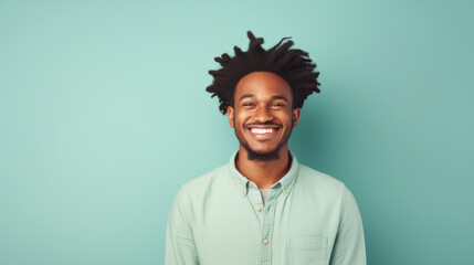 Obraz premium Joyful young man with trendy dreadlocks on a refreshing teal background