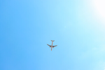 Single plane silhouette flying across a clear blue sky day