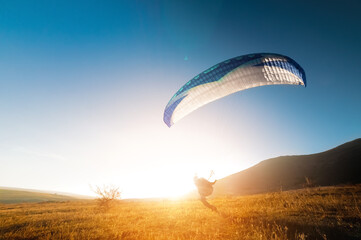 Launching a speedwing from a mountain. A paraglider is preparing to take off from a mountain,...