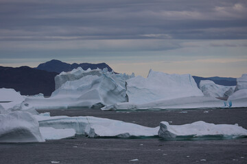 Icebergs in Ilulissat Icefjord with dramatic sky in Disko Bay, Greenland, Denmark