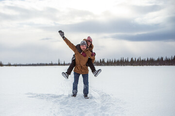Laughing husband and wife having fun in snowy tundra holidays