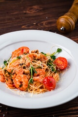 Pasta with shrimps, mussels, tomatoes, cheese and spices, Italian cuisine.