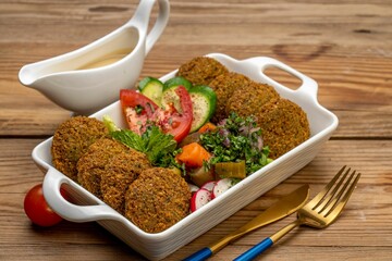 a bowl of mixed salad and chicken in a gravy dish