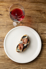 Tasty bruschetta with jamon and cheese on a wooden table