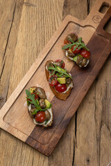 Tasty bruschetta with jamon and cheese on a wooden table