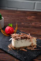 Piece of vanilla cheesecake with chocolate, scoop of ice cream and mint, sweet dessert.