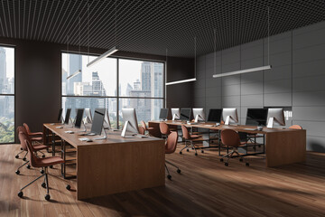 Stylish dark office interior with seats, pc monitors and desk in row near window