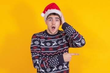 isolated young man or teenager with santa claus hat and christmas sweater