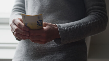 Woman Counting and Holding Money. Closeup Photo