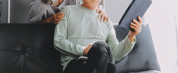Happy mature couple using laptop at home