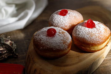 Hanukkah donutsand traditional spinning dreidel on a wooden board. Close up