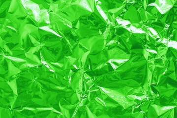Shiny green lime foil texture background, pattern of wrapping paper with crumpled and wavy.