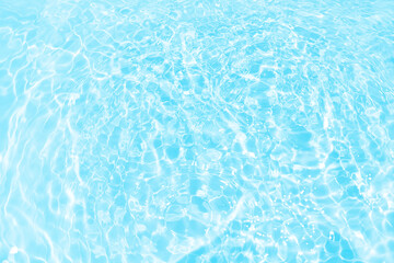 Defocus blurred transparent blue colored clear calm water surface texture with splashes reflection. Trendy abstract nature background. Water waves in sunlight with copy space. Blue watercolor shine.
