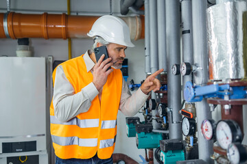 Engineer working in a thermal power plant and talking on the phone