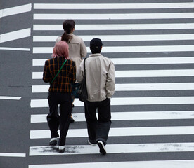 Obraz premium 都市の交差点の横断歩道を渡る若者たちの姿