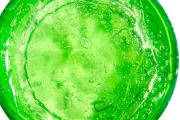 Transparent green cosmetic gel in a round jar. On an empty background.