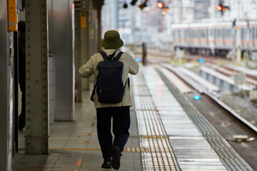 駅のホームで電車待ちの人々の姿