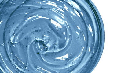 Transparent blue cosmetic gel in a round jar. View from above. On an empty background.