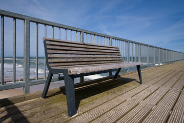 SEA COAST - A bench on the promenade pier in a seaside resort