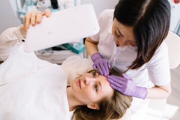 Obraz na płótnie Canvas Smiling female client having massage after procedure